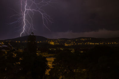 Illuminated cityscape against sky at night