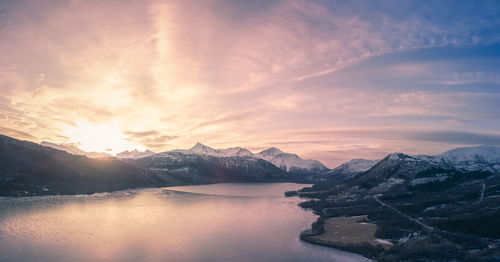 Scenic view of lake and mountains against sky during sunset