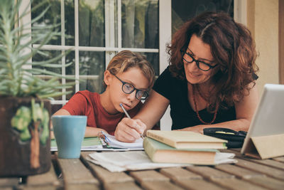 Mature woman helping son with studies at home