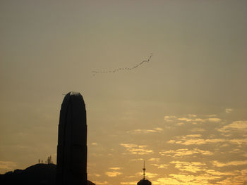 Low angle view of silhouette birds flying against sky during sunset