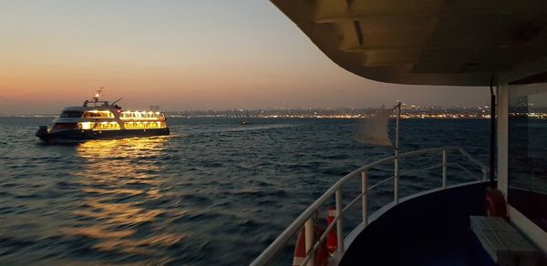 Ship sailing in sea against sky during sunset