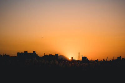 Silhouette buildings against sky during sunset