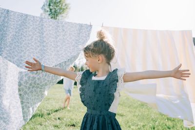 Girl dancing in the garden through the washing on the line