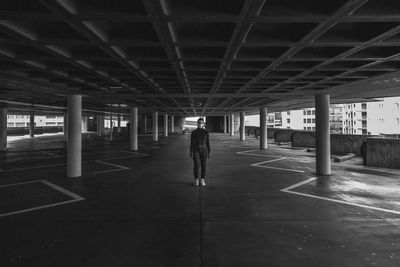 Rear view of man walking in parking lot