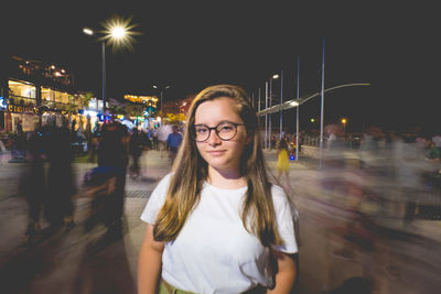 Portrait of young woman standing at night