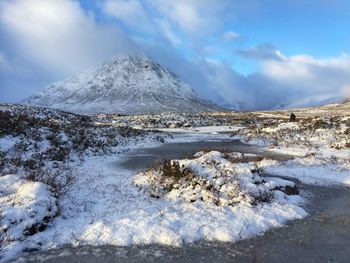 Scenic view of snow covered mountains against sky