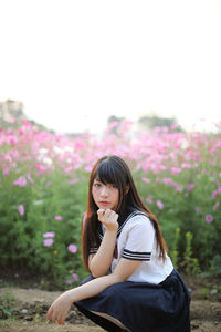 Portrait of beautiful young woman sitting by plants