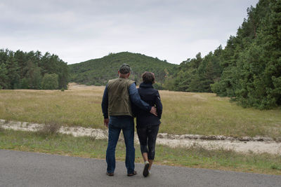 Rear view of man walking on road