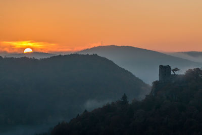 Scenic view of mountains against orange sky