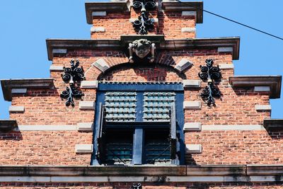 Low angle view of cross against building