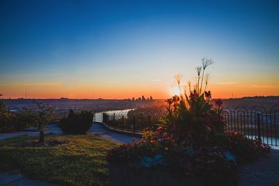 Scenic view of river against clear sky at sunset