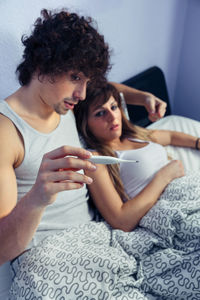 Close-up of young woman lying on bed at home