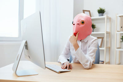 Rear view of female dentist working in office