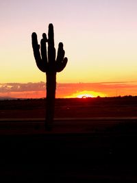 Silhouette hand against sunset sky