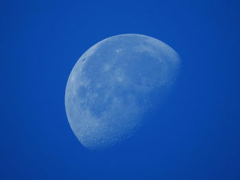 Low angle view of moon against blue sky