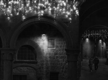 People walking on illuminated street at night