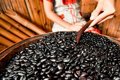 Midsection of woman holding coffee bean