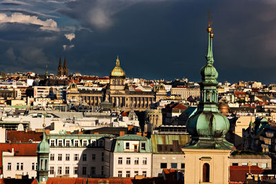 Buildings in city against cloudy sky