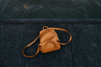 High angle view of brown backpack on pier over lake