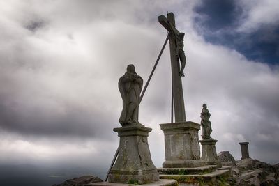 Low angle view of statue against cloudy sky