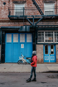 Rear view of man on street against building