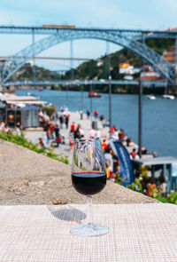 View of wine in glass on bridge against river in city