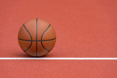 Close-up of basketball hoop against red background