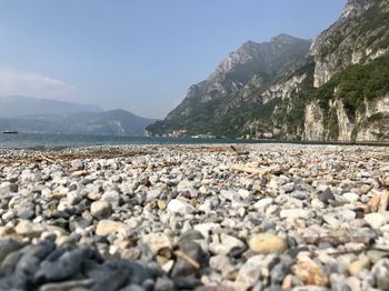 Stones in sea against sky