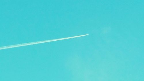 Low angle view of vapor trail against clear blue sky