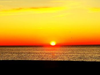 Scenic view of sea against romantic sky at sunset