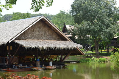 Built structure by trees and plants against sky