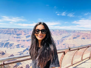 Portrait of young woman standing against mountain