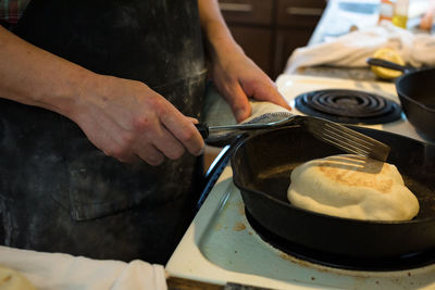 Midsection of man preparing food in kitchen