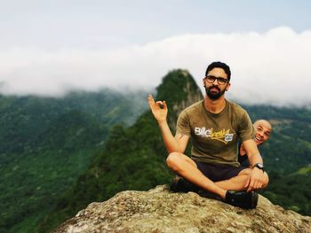 Young man sitting on rock