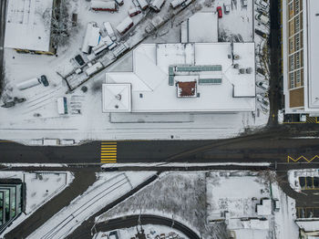 Snow covered railroad tracks amidst buildings during winter