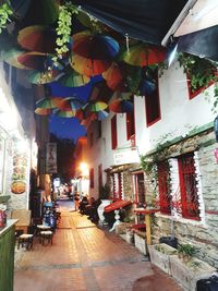 Illuminated lanterns hanging in market amidst buildings in city