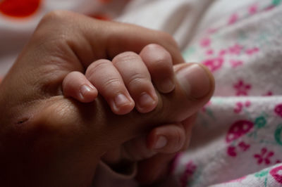 Close-up of baby hand on bed