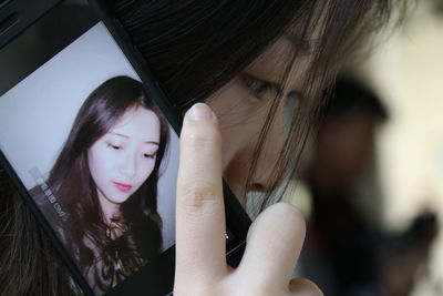 Close-up of young woman using mobile phone at home