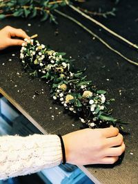 High angle view of woman hand holding flowering plant