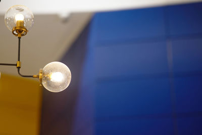 Low angle view of light bulb hanging on ceiling