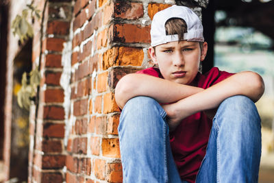 Portrait of a young man leaning against wall