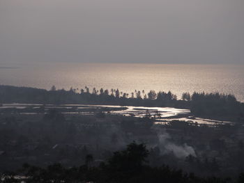 Scenic view of lake against sky during foggy weather