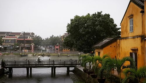 Trees and houses against sky during rainy season