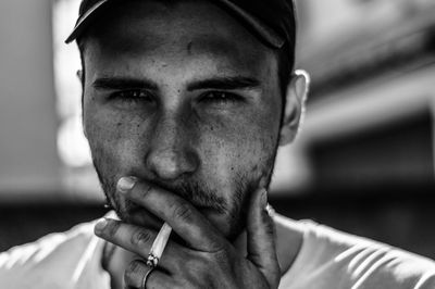 Close-up portrait of young man smoking cigarette