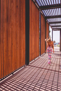 Rear view of woman standing on wood