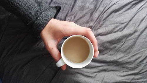 Close-up of hand holding coffee cup