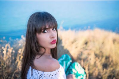 Portrait of woman sitting against sea