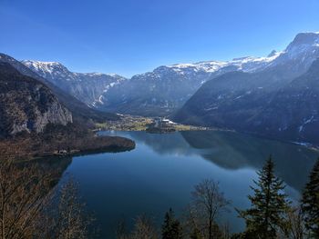 Scenic view of lake and mountains against blue sky