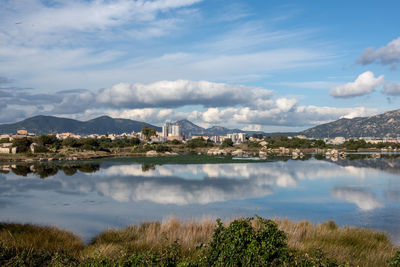 Scenic view of river by buildings against sky