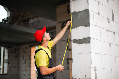 Rear view of woman standing against wall